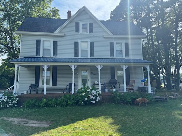22338 Accomac Rd, Accomac, VA 23301 - view of front of home with a porch, a chimney, a front lawn, and metal roof