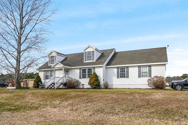 cape cod home featuring roof with shingles and a front yard