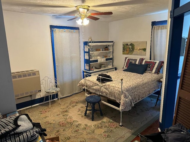 bedroom with a textured ceiling, heating unit, and ceiling fan