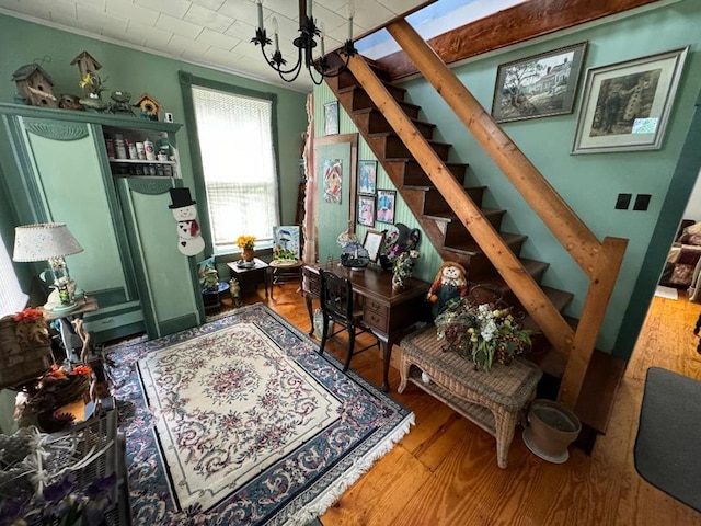 interior space with wood-type flooring, crown molding, and a notable chandelier