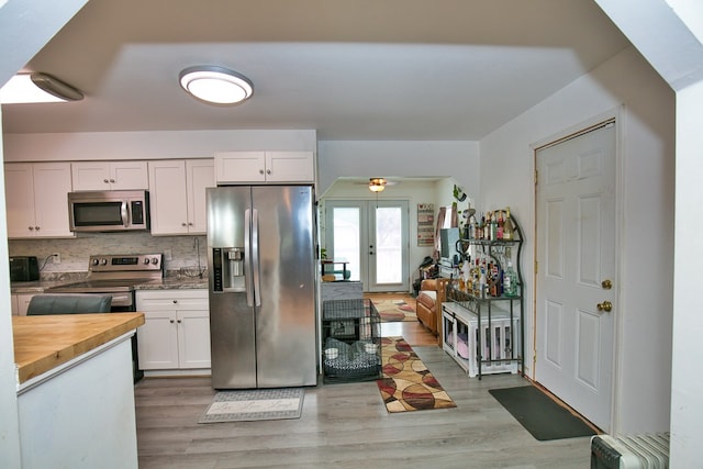 13091 Bethel Church Rd, Hallwood, VA 23359 - kitchen featuring stainless steel appliances, butcher block countertops, white cabinets, light wood-type flooring, and tasteful backsplash