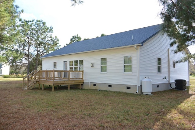 rear view of house featuring central AC unit, a deck, and a yard