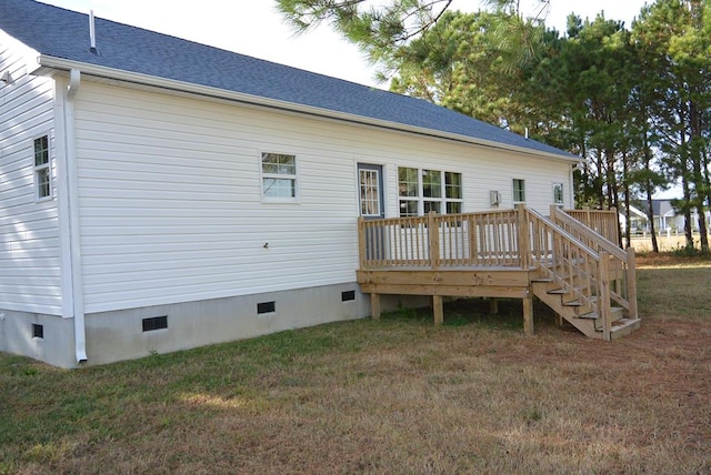 rear view of house with a lawn and a deck