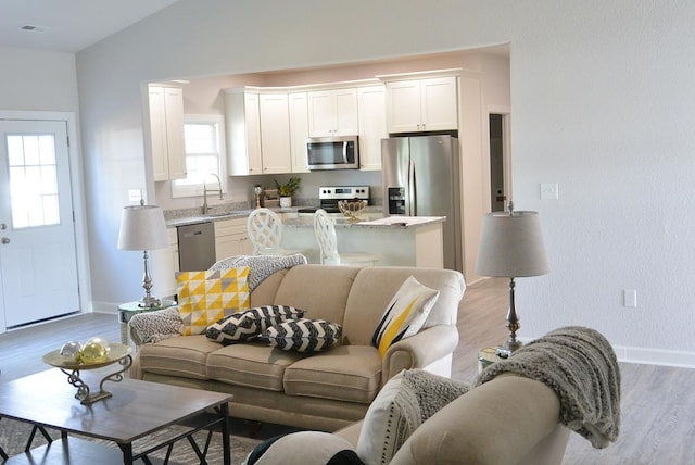 living room with light hardwood / wood-style floors and lofted ceiling