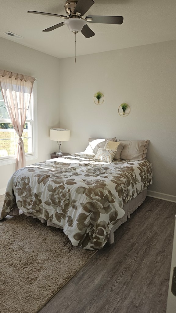 bedroom featuring ceiling fan and dark wood-type flooring