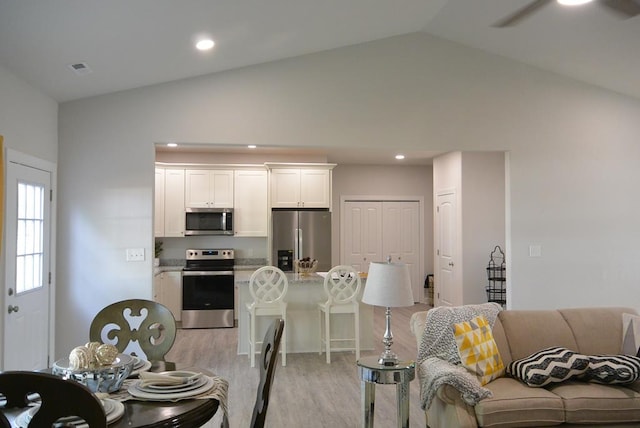 kitchen featuring white cabinetry, ceiling fan, light hardwood / wood-style flooring, vaulted ceiling, and appliances with stainless steel finishes