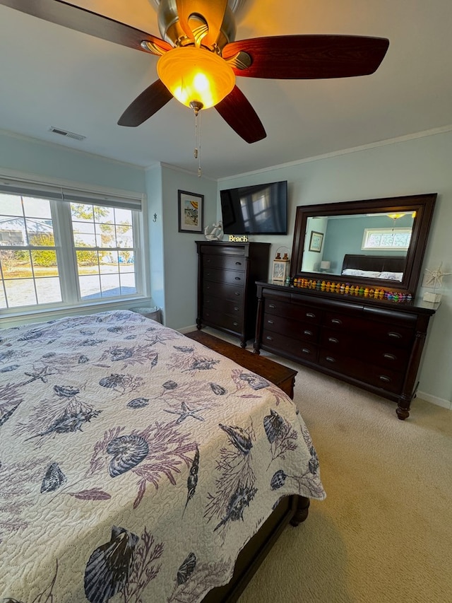 carpeted bedroom featuring crown molding and ceiling fan