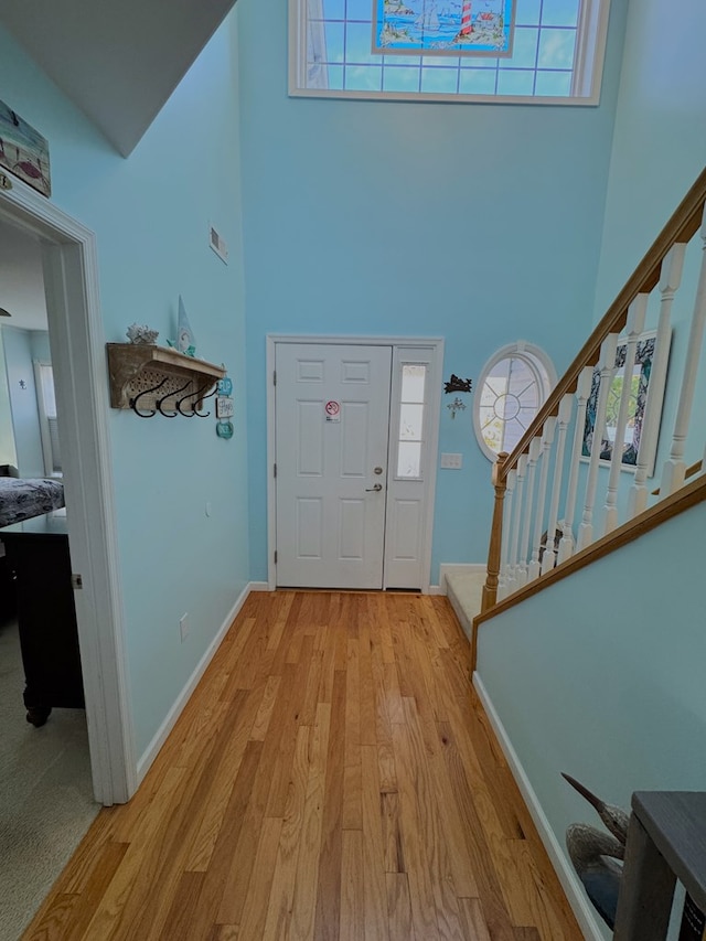 foyer featuring light hardwood / wood-style floors and a high ceiling