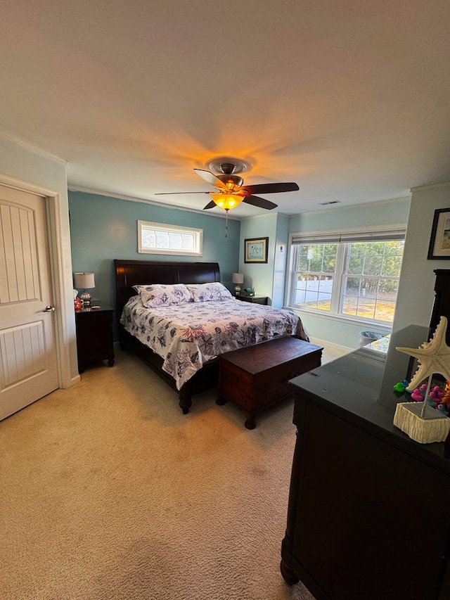 carpeted bedroom featuring crown molding and ceiling fan