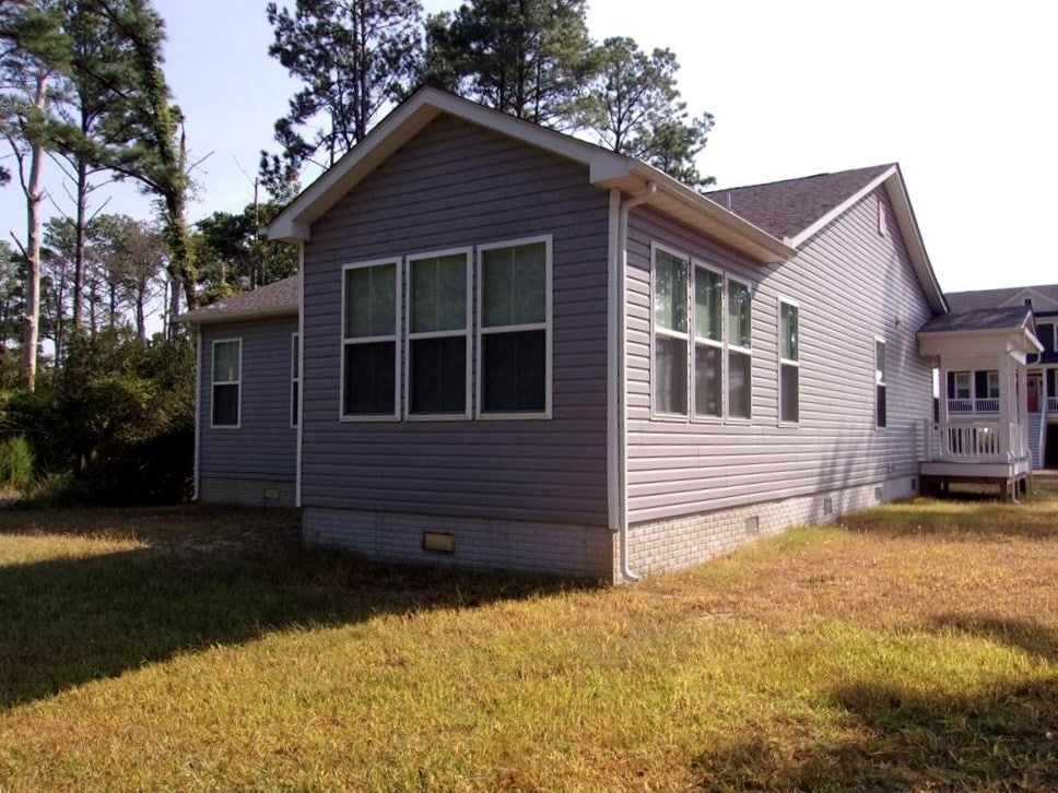 view of side of home with a lawn