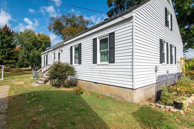 view of side of property featuring cooling unit and a lawn