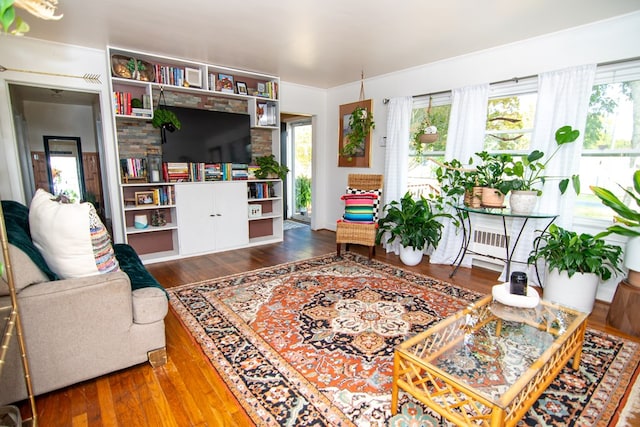 living area with plenty of natural light and hardwood / wood-style flooring