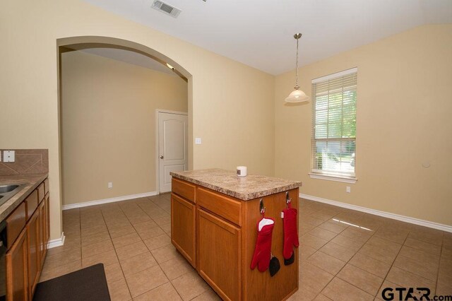 11017 Westhaven Cir, Flint, TX 75762 - kitchen featuring light tile patterned floors, arched walkways, decorative light fixtures, and brown cabinets