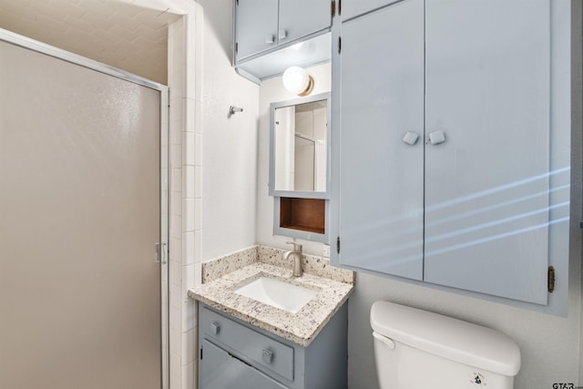 bathroom with toilet, an enclosed shower, and vanity