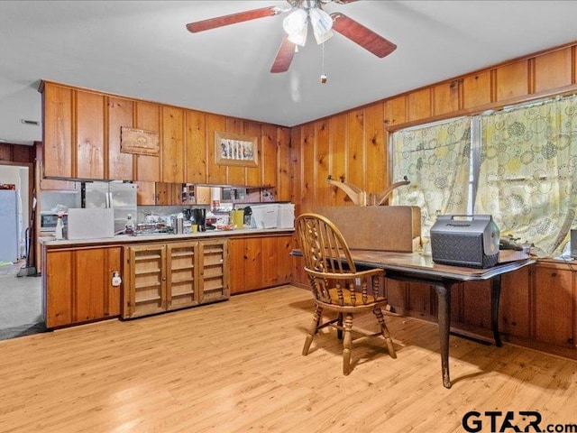 kitchen featuring ceiling fan, stainless steel refrigerator, and light wood-type flooring