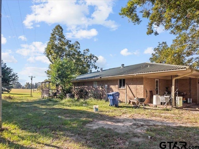 back of house with a patio and a lawn