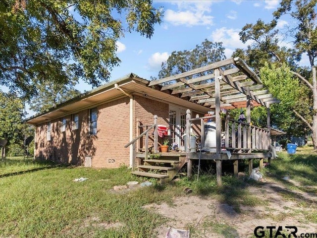 exterior space with a wooden deck, a pergola, and a yard