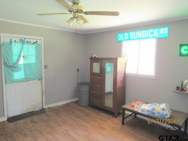 foyer entrance featuring hardwood / wood-style floors, ceiling fan, and crown molding