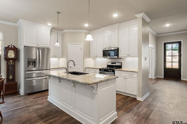 kitchen with white cabinetry, sink, stainless steel appliances, light stone countertops, and a center island with sink