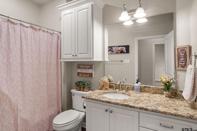 bathroom featuring curtained shower, vanity, toilet, and a notable chandelier