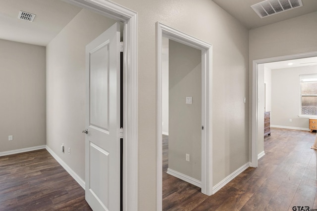 corridor with dark hardwood / wood-style flooring