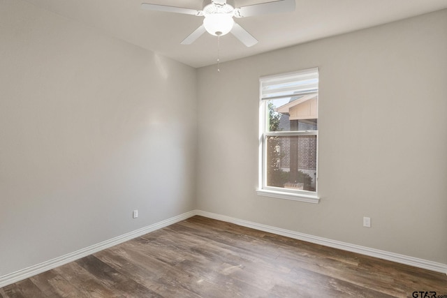 spare room with dark wood-type flooring and ceiling fan