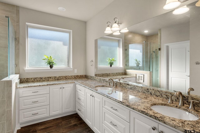 bathroom featuring vanity, hardwood / wood-style flooring, a shower with door, and a notable chandelier