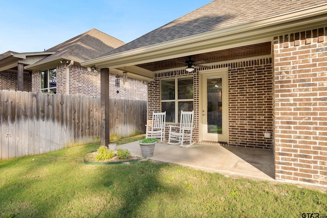 doorway to property with ceiling fan, a yard, and a patio area