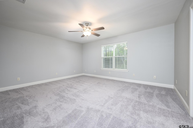 carpeted spare room with baseboards and ceiling fan