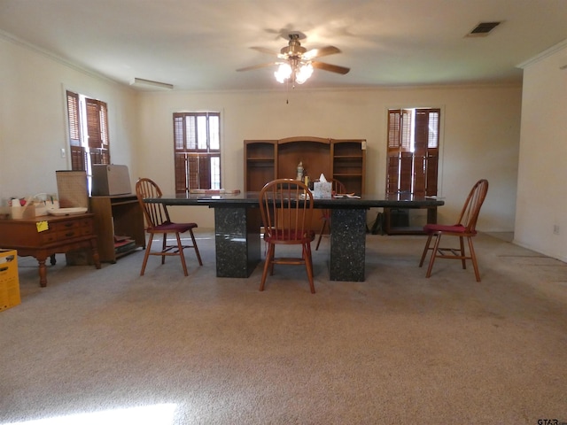 dining space with ceiling fan, ornamental molding, and carpet floors