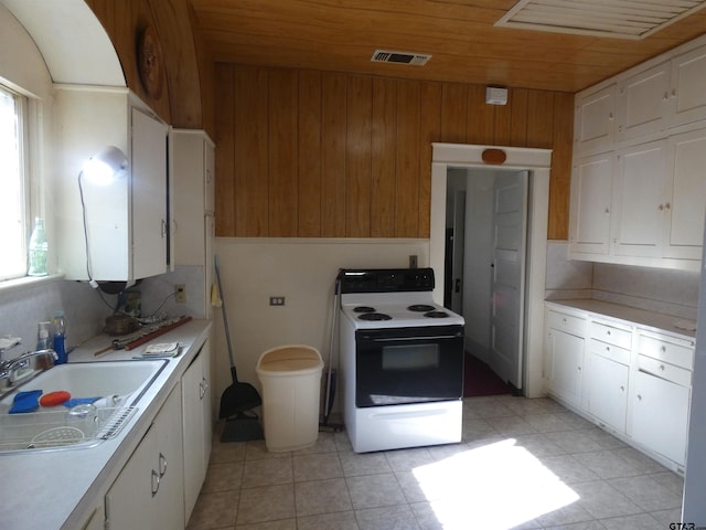 kitchen with white cabinets, wood ceiling, and electric stove