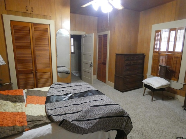 carpeted bedroom featuring ceiling fan and wooden walls