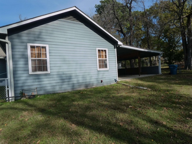 view of side of home featuring a yard and a carport