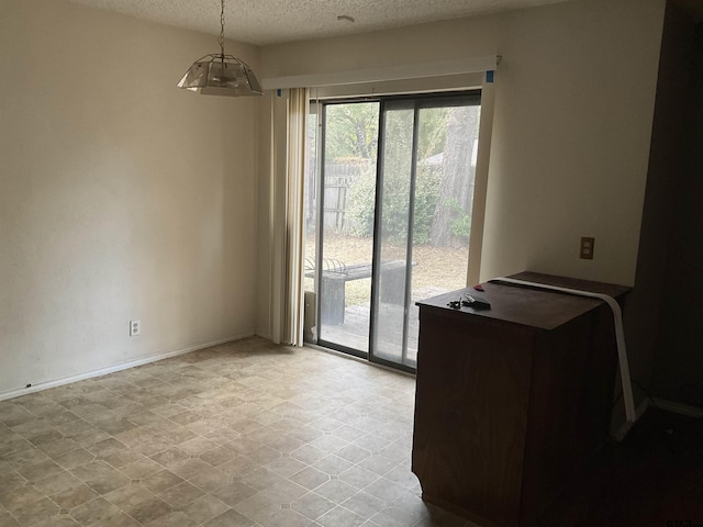 8307 Garrett Dr, Tyler, TX 75703 - unfurnished dining area with a textured ceiling and baseboards