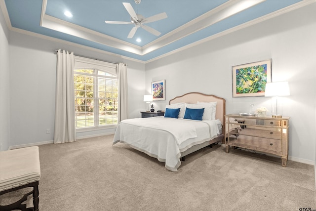 bedroom with light carpet, a tray ceiling, ornamental molding, and ceiling fan