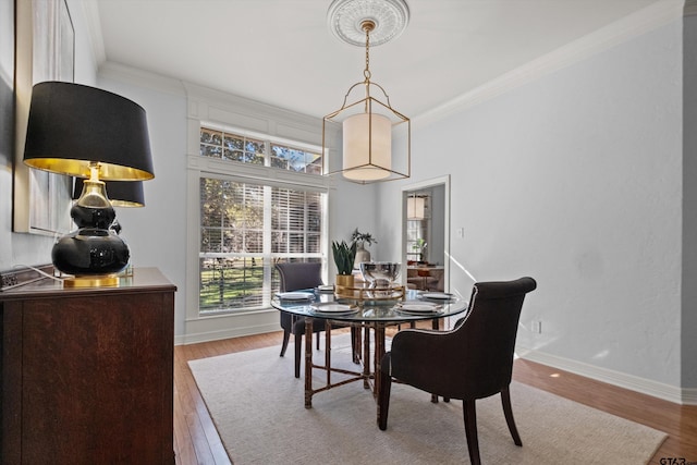 dining space with light hardwood / wood-style floors and crown molding