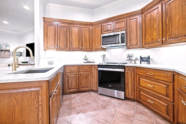 kitchen with light tile patterned flooring, sink, ornamental molding, appliances with stainless steel finishes, and kitchen peninsula