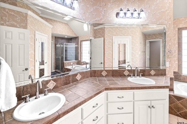 bathroom featuring shower with separate bathtub, vaulted ceiling, and vanity