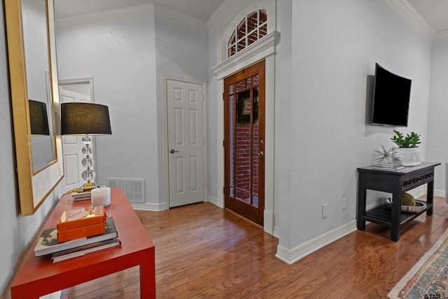 entrance foyer with ornamental molding and wood-type flooring