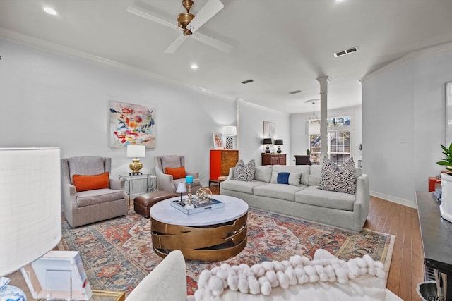 living room with hardwood / wood-style flooring, ceiling fan, and crown molding