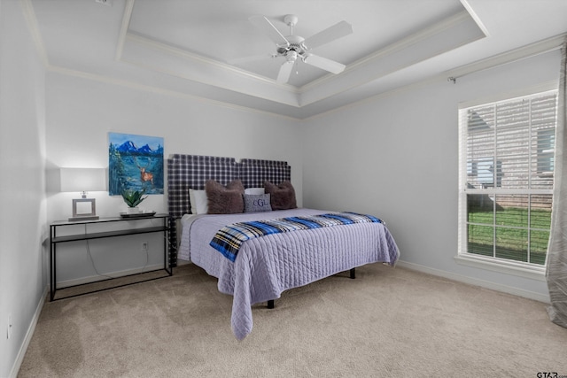 carpeted bedroom featuring a raised ceiling, ceiling fan, and crown molding