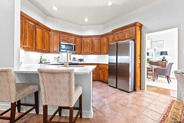 kitchen featuring appliances with stainless steel finishes, a breakfast bar, sink, and kitchen peninsula