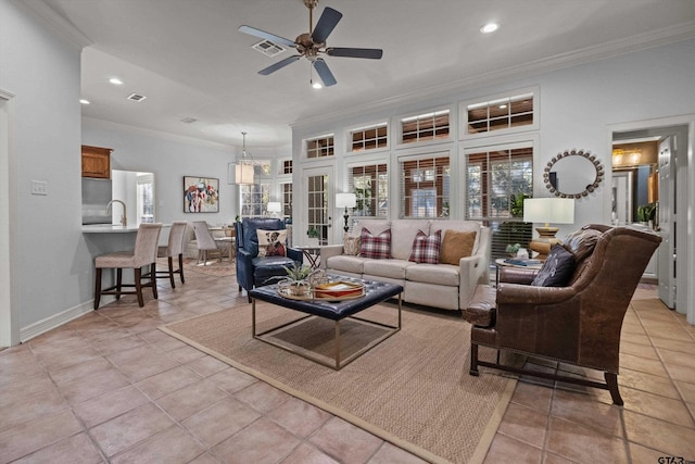 living room featuring light tile patterned floors, ceiling fan, and crown molding