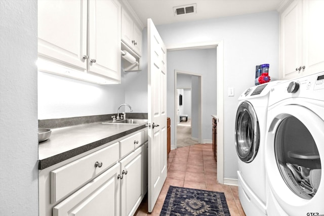 laundry room with cabinets, washing machine and clothes dryer, sink, and light tile patterned floors