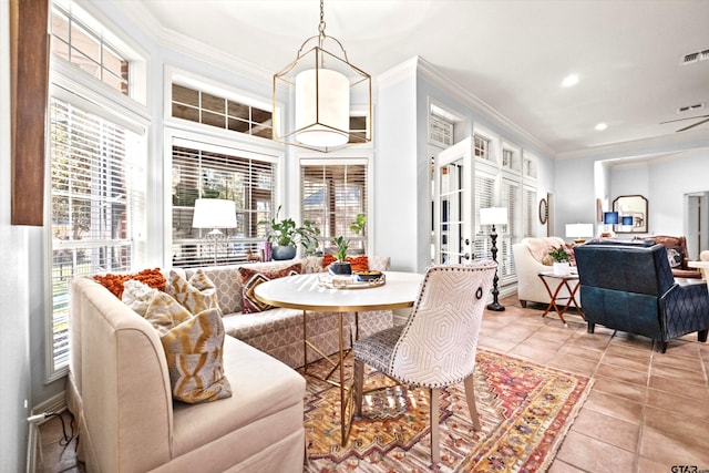 dining space featuring crown molding and light tile patterned floors