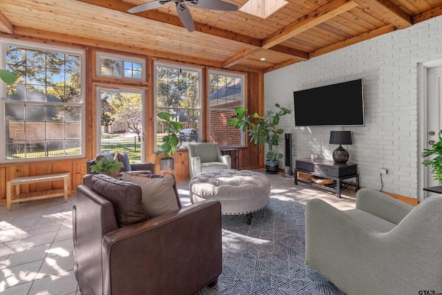 sunroom with beam ceiling, ceiling fan, a skylight, and wood ceiling