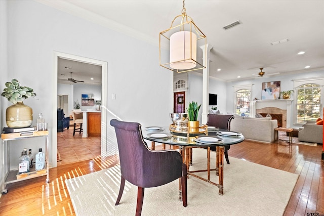 dining room featuring wood-type flooring, ornamental molding, and ceiling fan