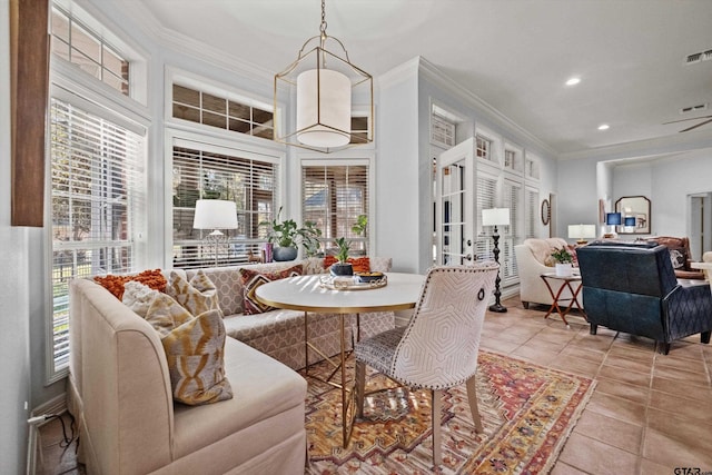 dining area with crown molding and light tile patterned floors