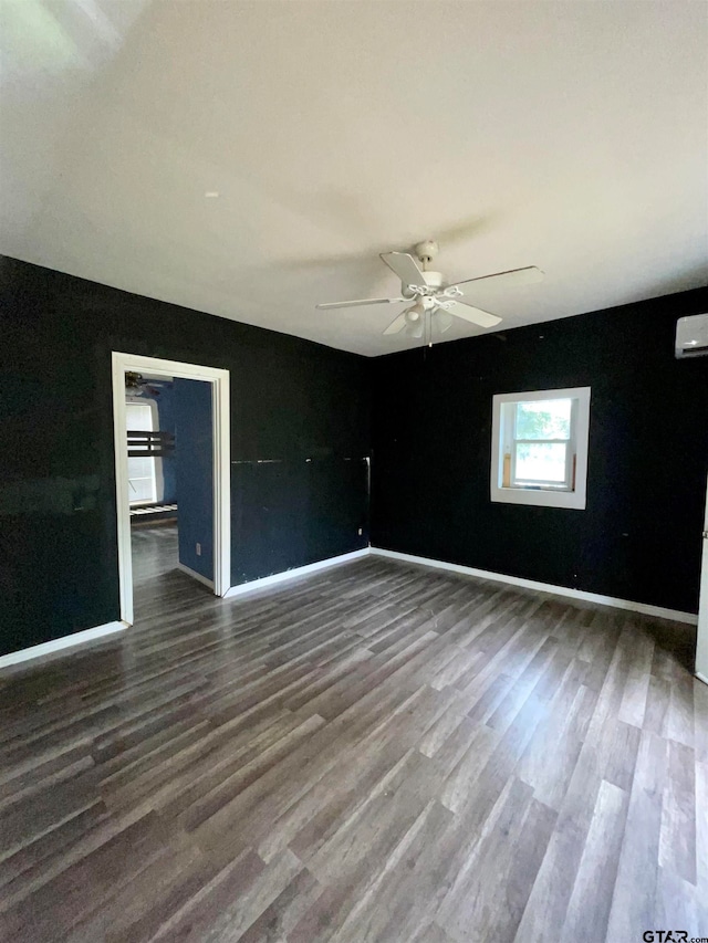 unfurnished room featuring a wall mounted AC, dark hardwood / wood-style floors, and ceiling fan