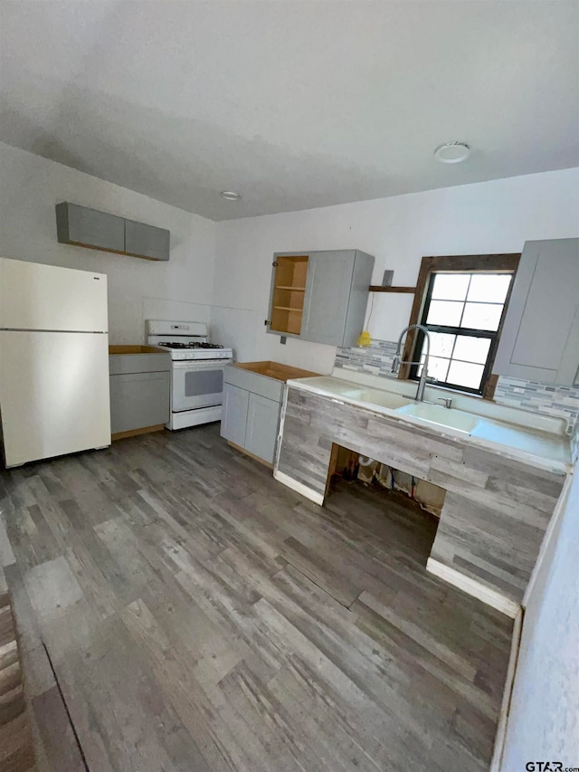 kitchen featuring gray cabinets, white appliances, backsplash, and hardwood / wood-style flooring